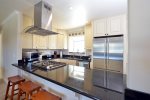 Kitchen includes a gas range, high end appliances and a breakfast bar.